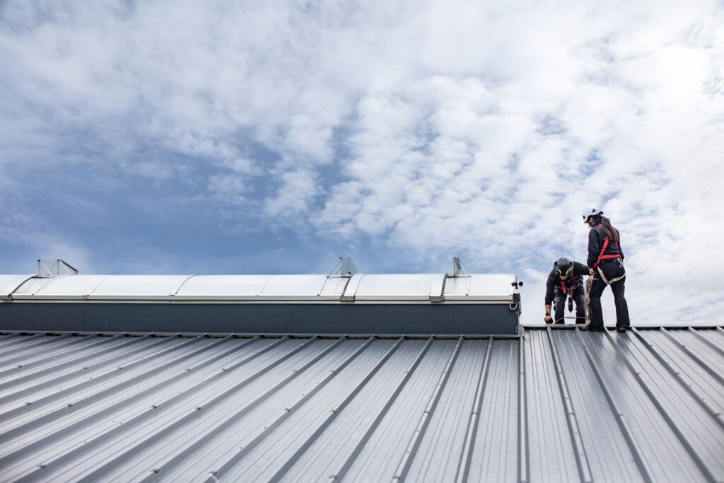 eamarbeit bei Dacharbeiten – Handwerker von Rixen Dach arbeiten gemeinsam auf dem Dach.