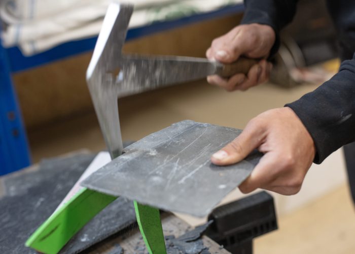 Handwerkliche Bearbeitung von Schieferschindeln durch Dachdecker bei Rixen Dach.